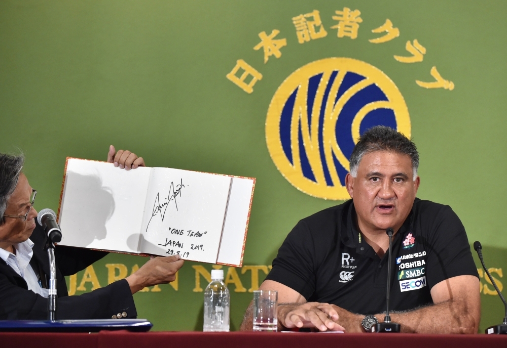 Japan's national rugby team head coach Jamie Joseph, right, explains his message 