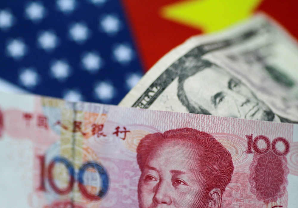 US dollar and China yuan notes are seen in this file picture illustration. — Reuters