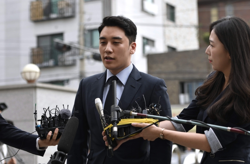 Former BIGBANG boyband member Seungri, center, real name Lee Seung-hyun, speaks to the media as he arrives for police questioning in Seoul on Wednesday. — AFP