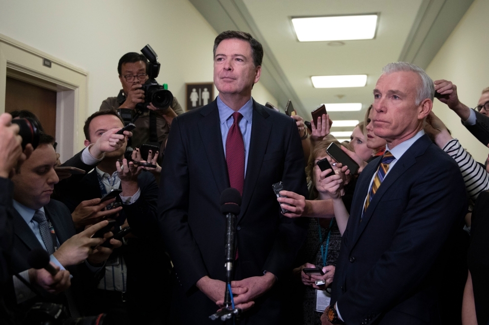 In this file photo taken on Dec. 7, 2018 Former FBI Director James Comey (C) talks to reporters following a closed House Judiciary Committee meeting to hear his testimony, on Capitol Hill in Washington, DC. Former FBI director James Comey violated the rules of the FBI by keeping records of his exchanges with Donald Trump but did not transmit confidential information to the press, according to an official report released on Thursday. — AFP