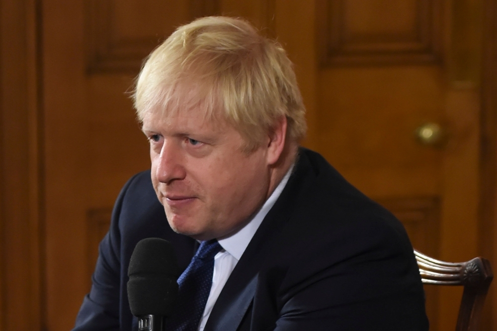 Britain's Prime Minister Boris Johnson speaks inside 10 Downing Street in London on Friday. — AFP