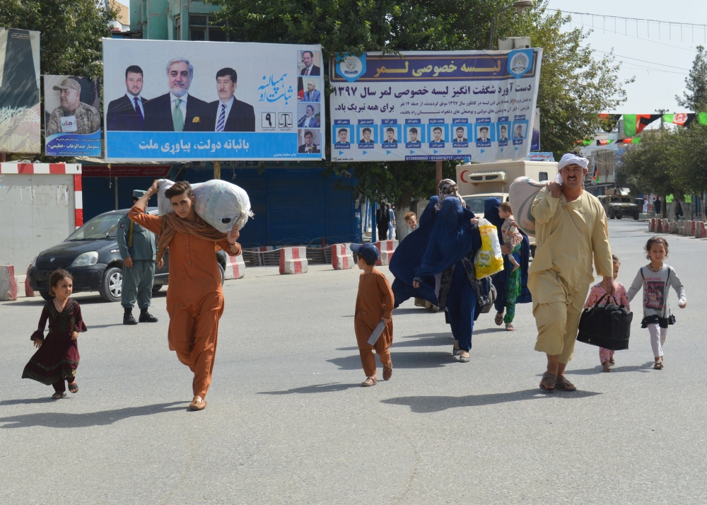 People leave an area during a Taliban attack, in the downtown of Kunduz city, Afghanistan Saturday. — Reuters