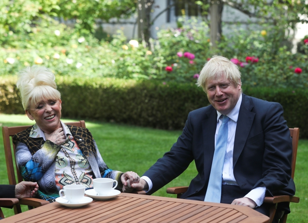 Britain's Prime Minister Boris Johnson and actress Barbara Windsor hold hands after she delivers a petition calling for urgent action on dementia care in the garden at 10 Downing Street, Monday. — AFP