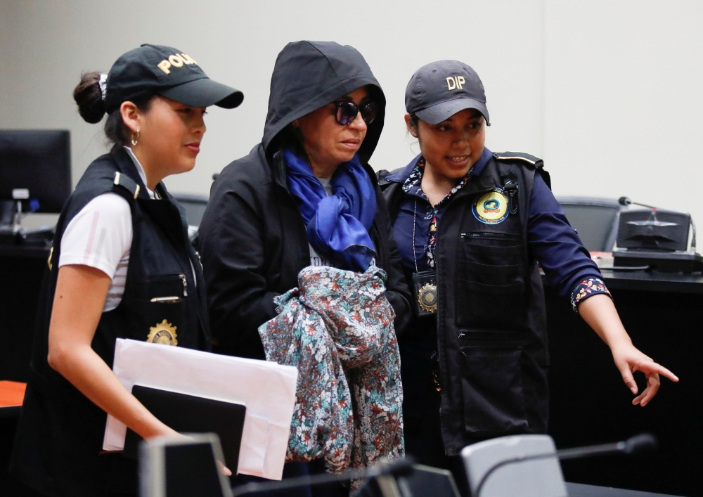 Police officers escort Sandra Torres, former first lady and presidential candidate of the National Unity of Hope (UNE) political party, after a hearing in Guatemala City, Guatemala on Monday. -Reuters