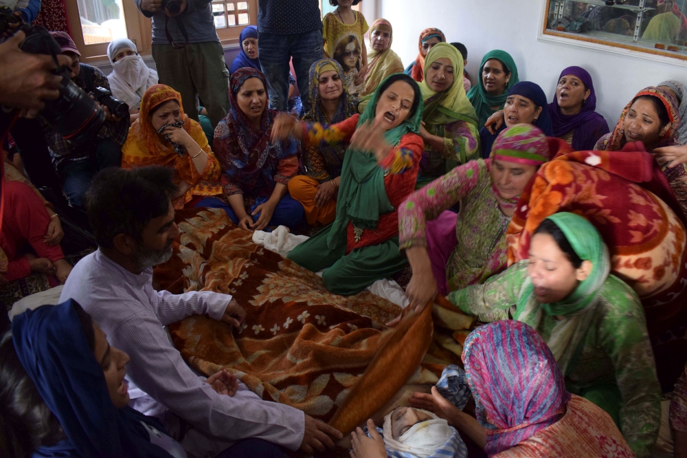 Relatives mourn around the body of Asrar Ahmed Khan, who died on Tuesday night after succumbing to wounds during a protest on August 6, in Srinagar, on Wednesday. — Reuters