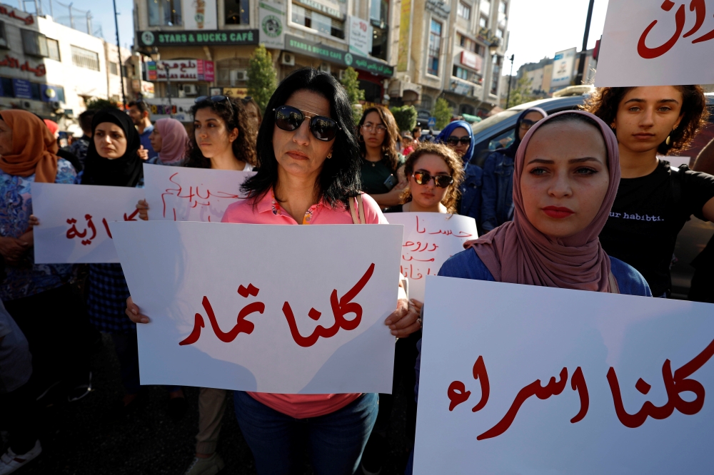 Demonstrators hold signs during a protest demanding legal protection for women in Ramallah in the Israeli-occupied West Bank on Wednesday. — Reuters