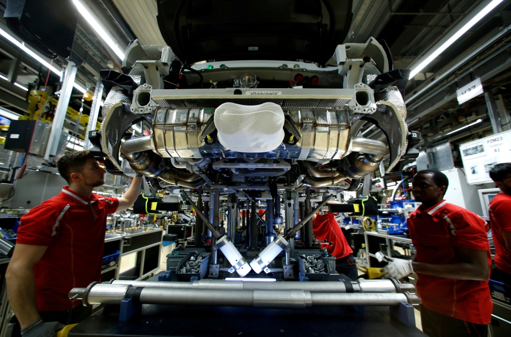 Employees of German car manufacturer Porsche work on a sports car at the Porsche factory in Stuttgart-Zuffenhausen, Germany, in this Jan. 26, 2018 file photo. — Reuters
