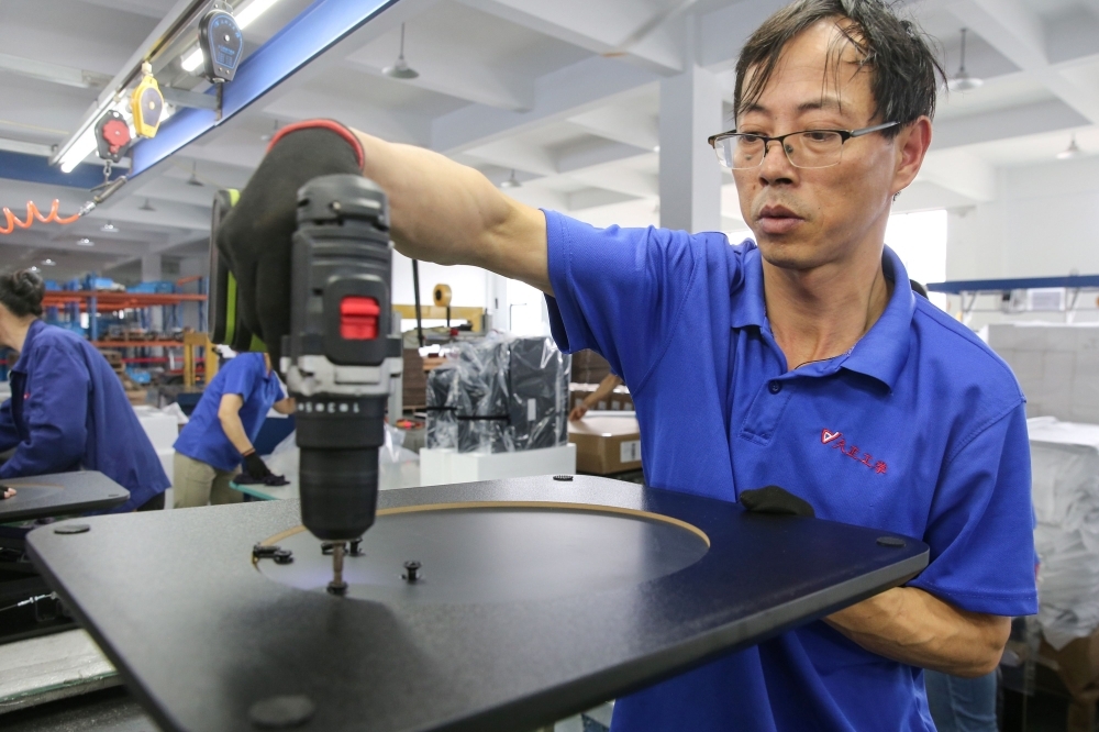 A worker produces desks for export to the US, France, Germany and other countries, at a factory in Nantong in China's eastern Jiangsu province, on Wednesday. — AFP