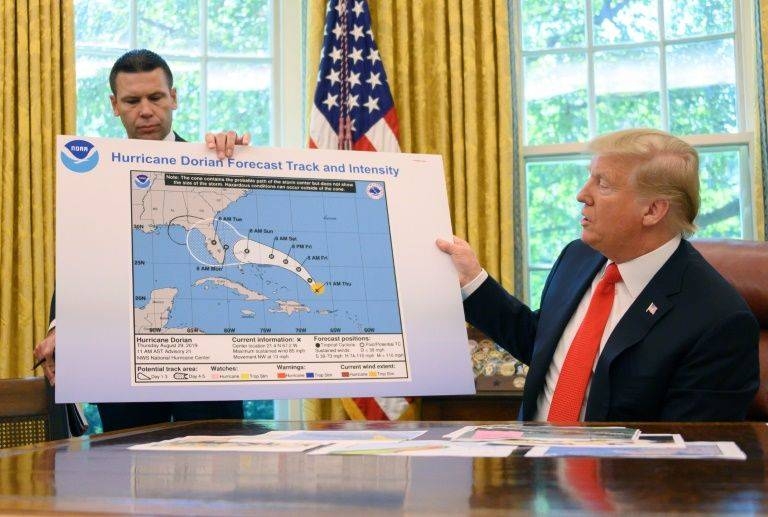 US President Donald Trump examines a weather map showing an early projection of Hurricane Dorian's path - with a bulge added apparently by Sharpie pen into Alabama. -AFP