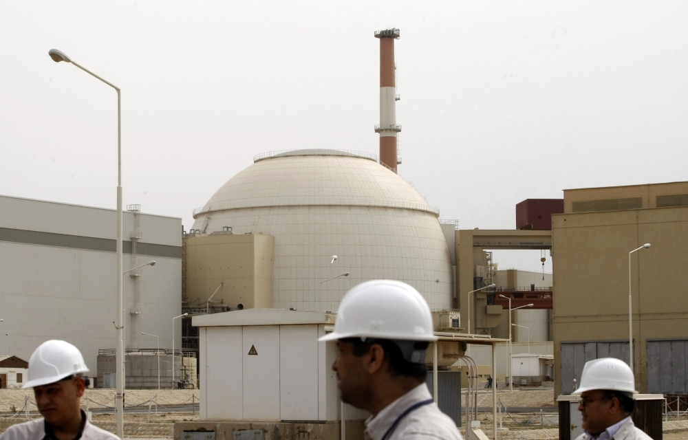 (FILES) In this file photo taken on February 25, 2009, Iranian technicians walk outside the building housing the reactor of Bushehr nuclear power plant at the Iranian port town of Bushehr, 1200 Kms south of the capital Tehran. Iran has started up advanced centrifuges to boost its stockpile of enriched uranium but will allow the UN atomic agency to continue monitoring its nuclear programme, a spokesman said on September 7, 2019. / AFP / Behrouz MEHRI
