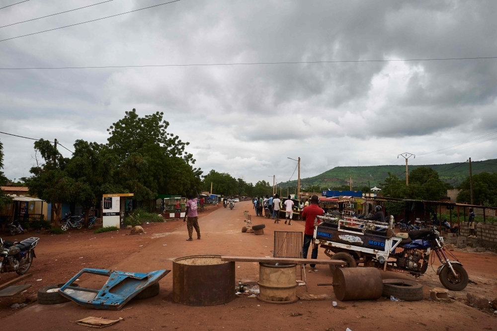 Malian people stand next to a barricade set up on the main road between Mali's capital Bamako and the western city of Kayes, to protest against the road's poor condition, in this Aug. 27, 2019 file photo. — AFP