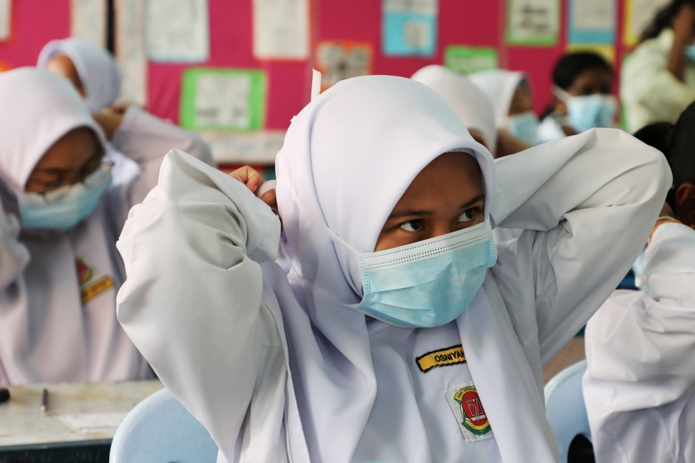 Students cover their faces with masks at a school in Puchong as haze shrouds Kuala Lumpur, Malaysia, Thursday. — Reuters