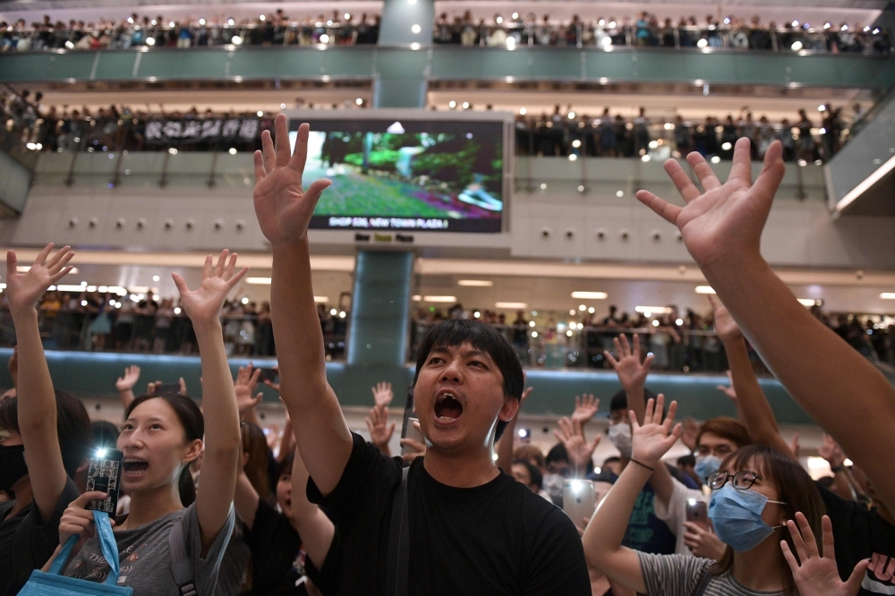 People gather at a shopping mall in the Shatin area of Hong Kong on Wednesday, to sing a recently penned protest song titled 'Glory to Hong Kong’ which has been gaining popularity in the city. — AFP