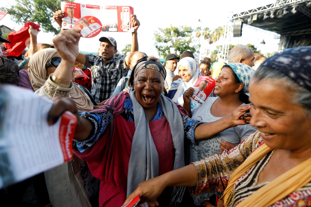 Supporters of presidential candidate in detention, Tunisian media mogul Nabil Karoui, carry his pictures during an election campaign rally in Tunis, Tunisia, on Friday. — Reuters