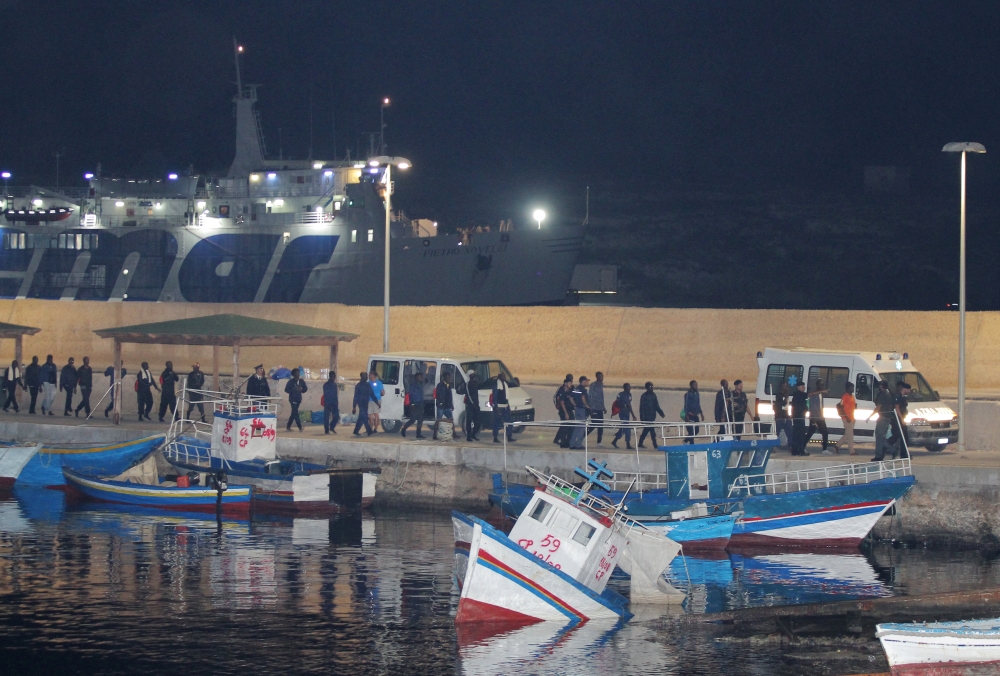 Migrants walk towards vehicles at the port in Lampedusa after the Italian government allowed the disembarkation of 82 migrants on board the rescue ship Ocean Viking, on Saturday. -Courtesy photo