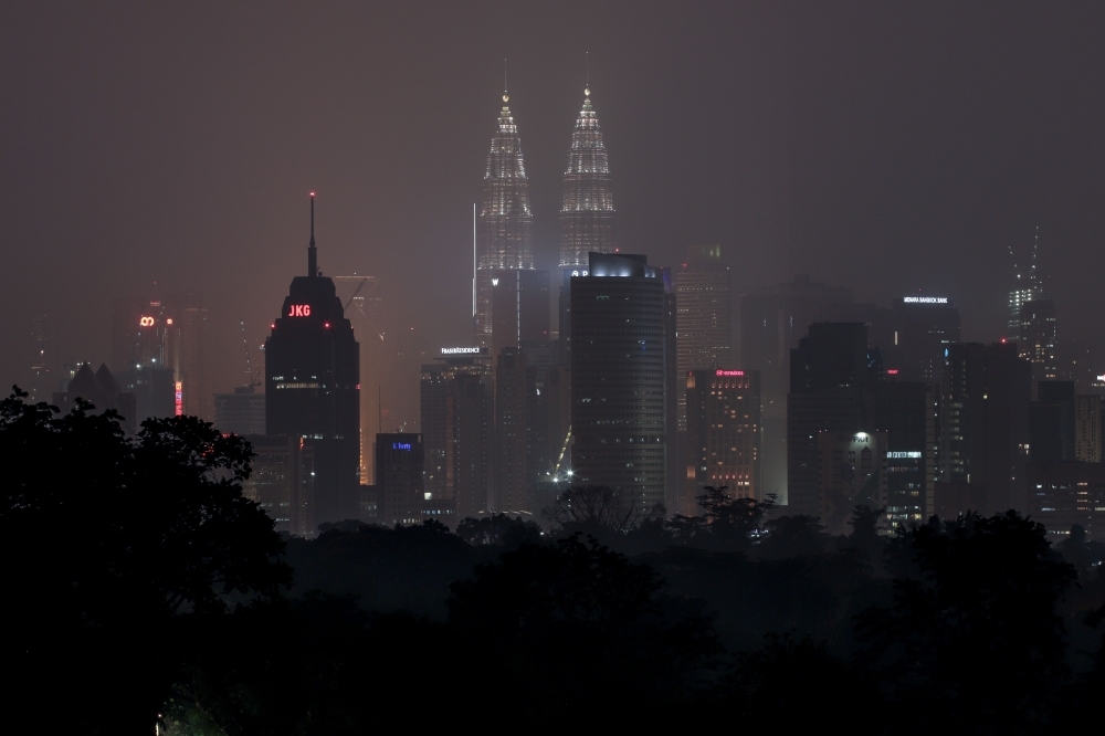 Malaysia's capital skyline with the Petronas Twin Towers (L) and Kuala Lumpur Tower (R) landmarks is blanketed by haze in Kuala Lumpur on Wednesday. Toxic haze from Indonesian forest fires closed thousands of schools across the country and in neighboring Malaysia, while air quality worsened in Singapore just days before the city's Formula One motor race. — AFP