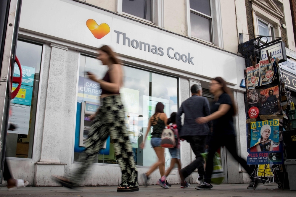 In this file photo taken on July 12, 2019, pedestrians walk past a branch of a Thomas Cook travel agent's shop in London. Thomas Cook's 178-year existence was hanging by a thread on Sunday after the iconic British travel firm struggled to find further private investment and is now relying on an unlikely government bailout. — AFP