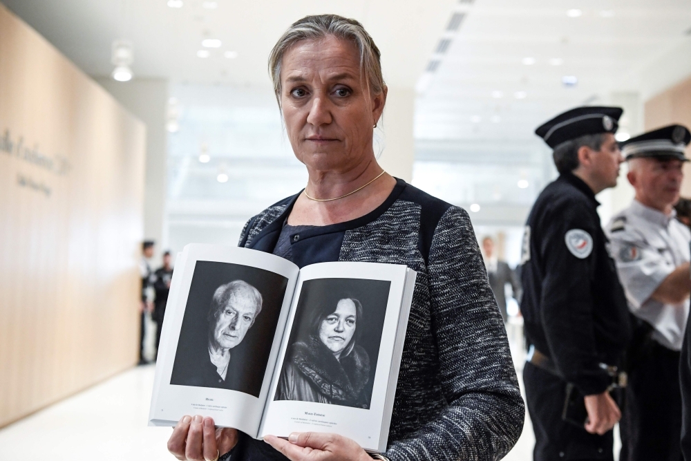 French pulmonologist Irene Frachon poses with a photobook depicting portraits of 