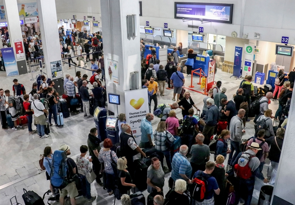 Tourists wait at a Thomas Cook company counter at Heraklion airport on the island of Crete on Monday.  British travel group Thomas Cook declared bankruptcy after failing to reach a last-ditch rescue deal, triggering the UK's biggest repatriation since World War II to bring back stranded passengers. The 178-year-old operator had been desperately seeking £200 million ($250 million, 227 million euros) from private investors to save it from collapse. — AFP