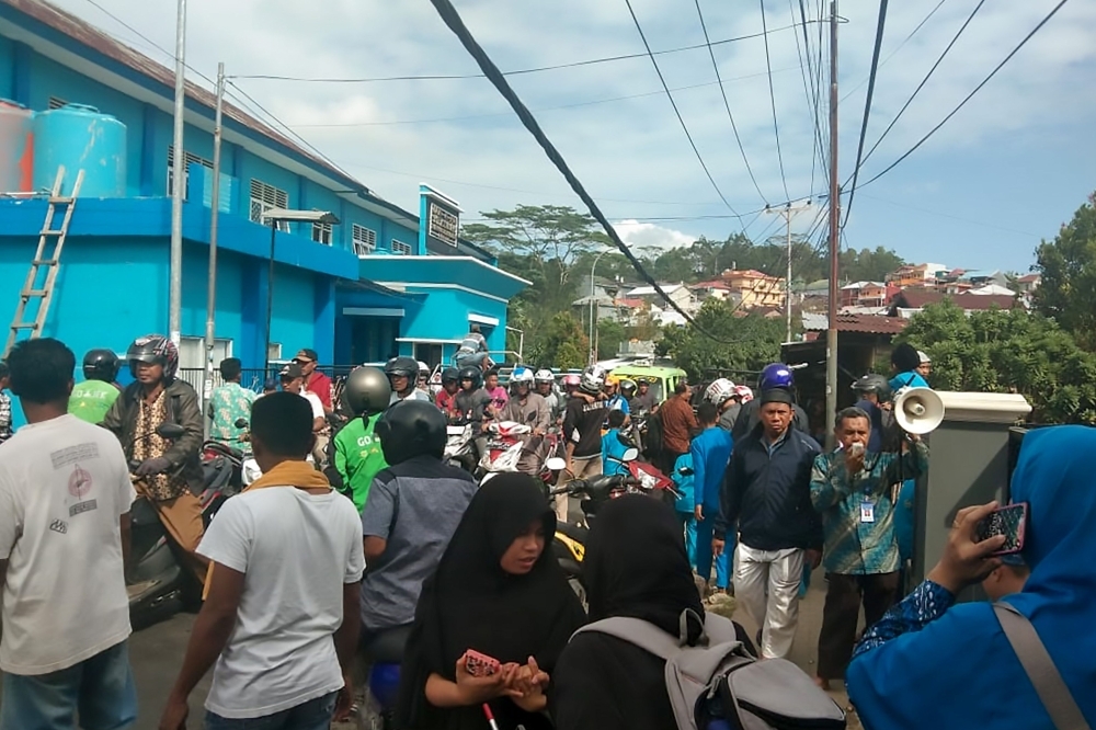 People gather outdoors at Batu Merah village in Ambon, Indonesia's Maluku islands, following a 6.5-magnitude earthquake on Thursday. — AFP