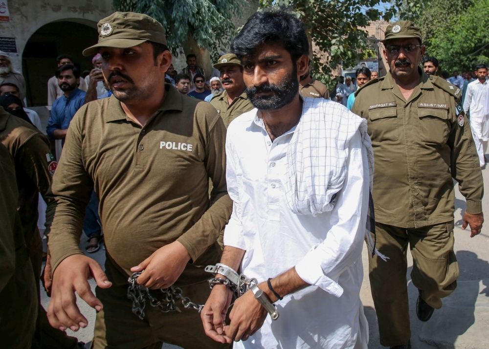 Policemen escort hand-cuffed Muhammad Waseem (C), the brother of slain social media celebrity Qandeel Baloch, as he leaves the court after the verdict in Multan on Friday. The brother of Pakistani social media star Qandeel Baloch was sentenced to life in prison for her murder — the patriarchal country's highest-profile 