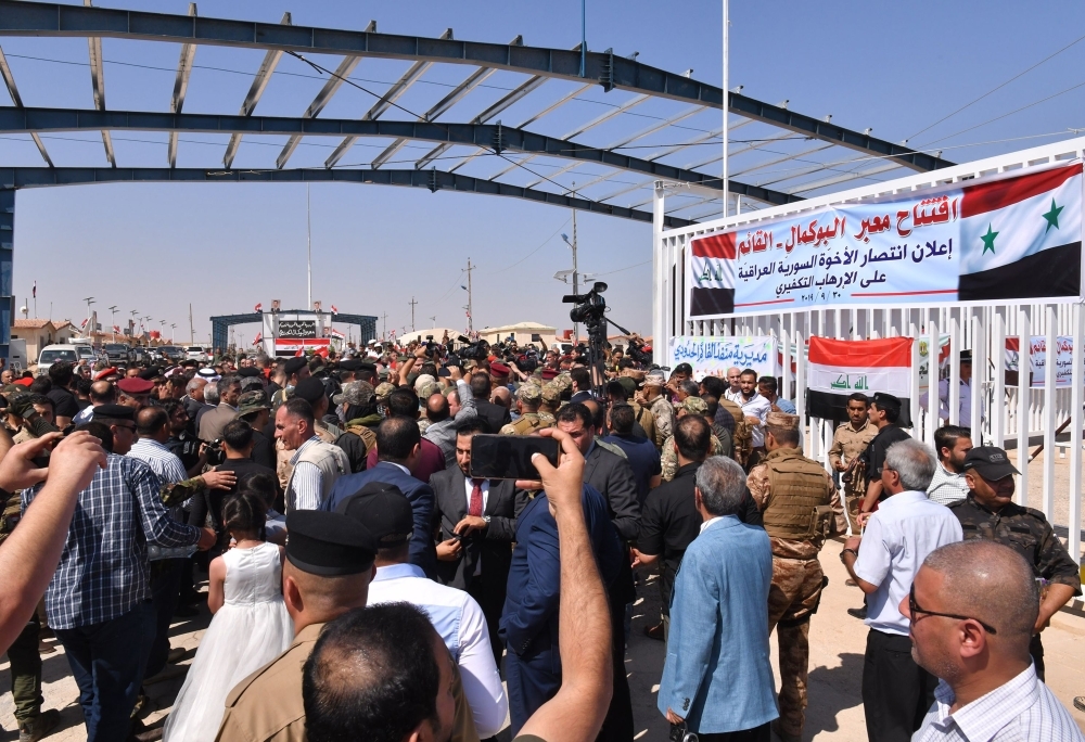 People and media flood the Syrian side of the border-crossing between Albu Kamal in Syria and Al-Qaim in Iraq, on Monday. — AFP