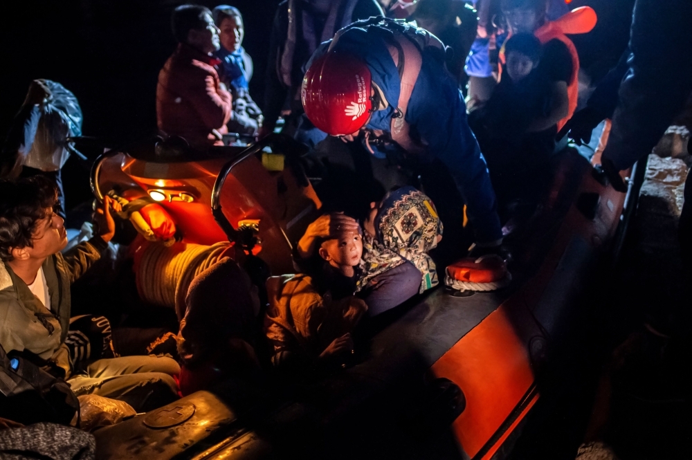 Migrants are seen on board a ''Refugee Rescue NGO'' rescue boat, following a rescue operation by a Frontex patrol vessel, at the port of Skala Sikamias, on the island of Lesbos, the forefront island for refugee and migrant arrivals from Turkey, one of five Greek islands in the Aegean sitting just off the Turkish coast, on Wednesday. — AFP