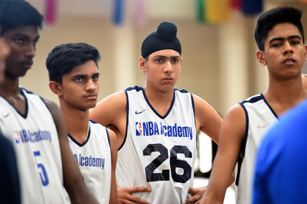 This photo taken on Sept. 13, 2019 shows trainee basketball players listening to Ronald Cass, player development coach of the National Basketball Association (NBA) Academy India, at Jaypee Sports City Greater Noida, on the outskirts of New Delhi in Uttar Pradesh state. — AFP