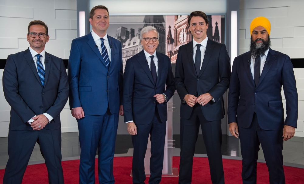 Leader of the Bloc quebecois Yves-François Blanchet, left, Leader of the Conservative Party of Canada Andrew Scheer, second left, Canadian journalist Pierre Bruneau, center, Prime Minister and Leader of the Liberal Party of Canada Justin Trudeau, second right, and Leader of the New Democratic Party Jagmeet Singh, right, pose for pictures ahead of the French debate for the 2019 federal election, the 