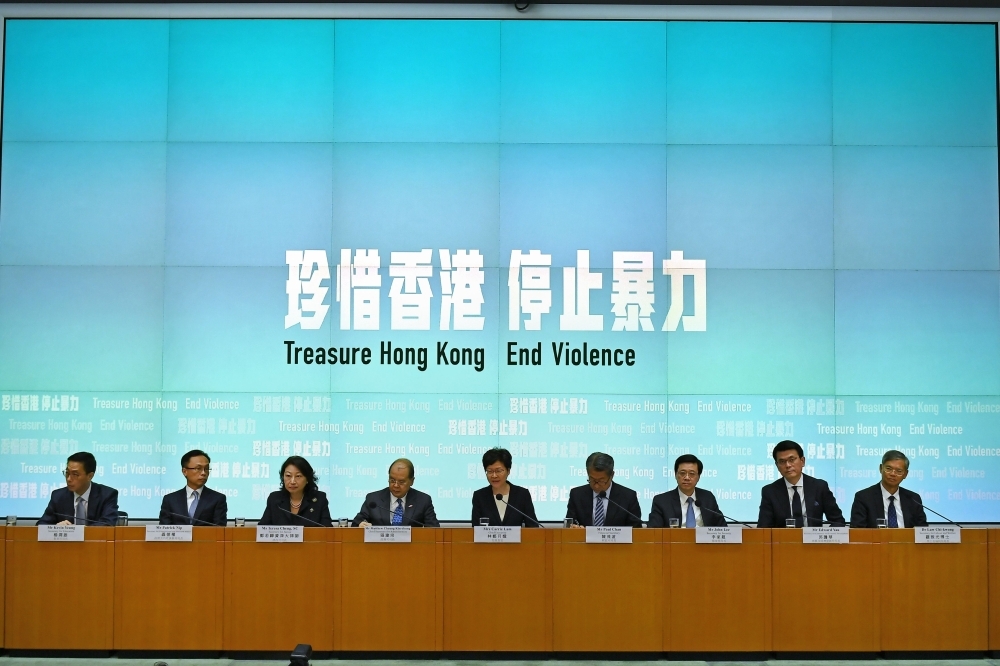 Hong Kong Chief Executive Carrie Lam (C) takes part in a press conference with her Cabinet in Hong Kong on Friday. Hong Kong's leader invoked a rarely used colonial-era emergency law to ban people from wearing face masks in a bid to put an end to months of violent protests. — AFP