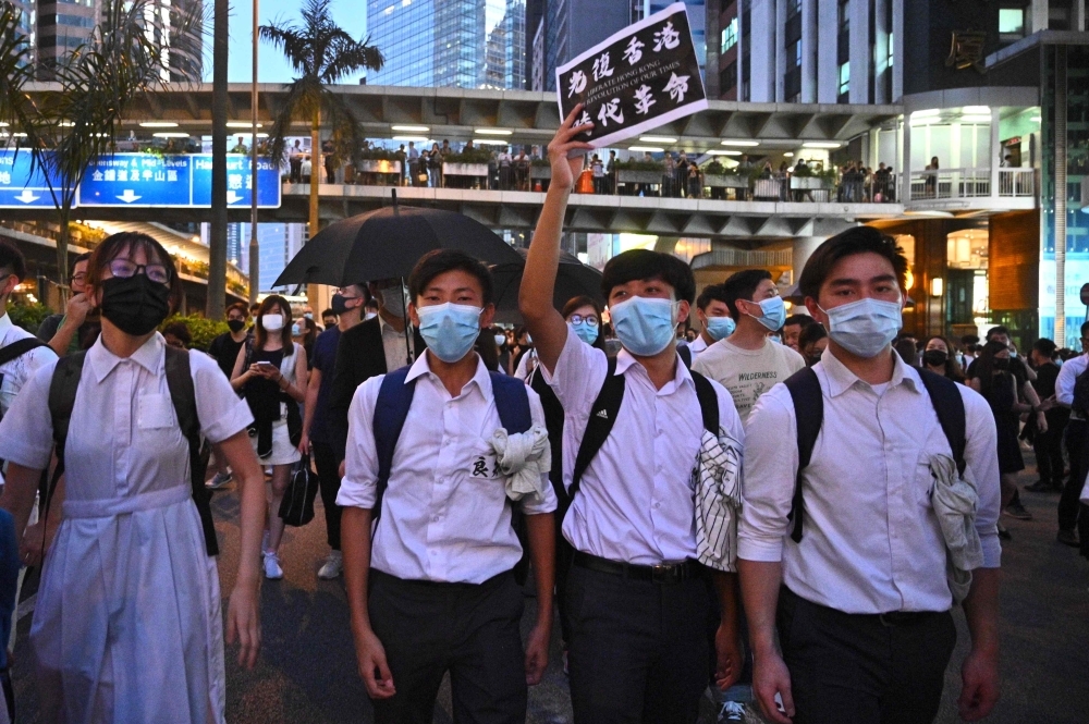 Hong Kong Chief Executive Carrie Lam (C) takes part in a press conference with her Cabinet in Hong Kong on Friday. Hong Kong's leader invoked a rarely used colonial-era emergency law to ban people from wearing face masks in a bid to put an end to months of violent protests. — AFP