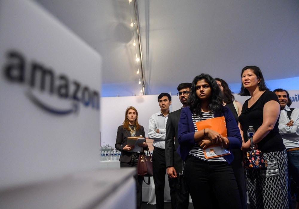 Job hunters wait to speak with Amazon recruiters at an Amazon Career Day event, where recruiters help candidates build interview skills, prepare them for job interviews and give them more information on the roles within the company, at Crystal City in Arlington, Virginia, in this Sept. 17, 2019 file photo. — AFP