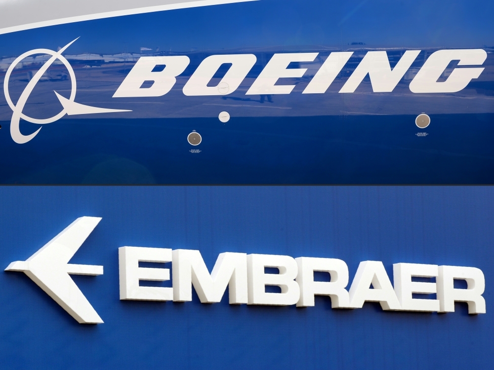This combination of file pictures created on Dec. 21, 2017 shows the Boeing logo on the fuselage of a Boeing 787-10 Dreamliner test plane presented on the tarmac of Le Bourget airport near Paris on June 18, 2017, and the logo of Brazil's aircraft manufacturer Embraer also taken at Le Bourget airport, on June 23, 2013. — AFP