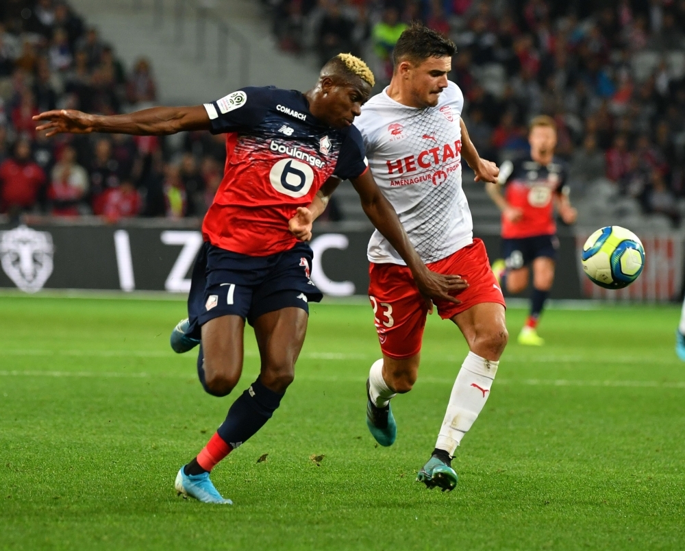Lille's Nigerian forward Victor Osimhen (L) vies with Nimes' French defender Anthony Briancon during the French L1 football match between Lille and Nimes at the Pierre-Mauroy stadium in Villeneuve-d'Ascq, near Lille, northern France, on Sunday. — AFP