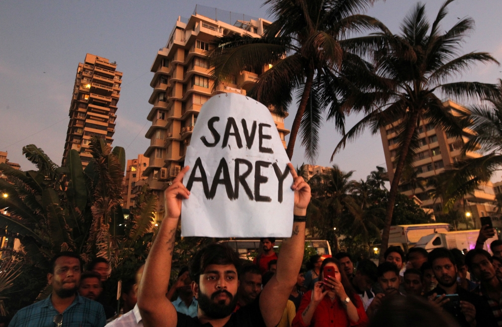 A man displays a placard at a promenade during a protest demanding that the Mumbai Metro Rail Corp Ltd (MMRCL) not cut trees to build a train parking shed for an upcoming subway line, in Mumbai, India on Sunday.  -Reuters