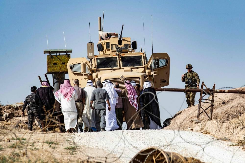 Syrian Kurds take part in a demonstration against Turkish threats at a US-led international coalition base on the outskirts of Ras Al-Ain town in Syria's Hasakeh province near the Turkish border on Sunday. — AFP