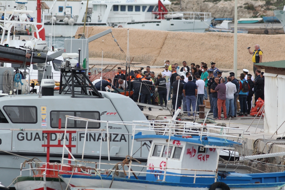 Rescue personnel carry a stretcher off a rescue vessel, after a ship carrying some 50 migrants began taking on water off the coast of Lampedusa, Italy, on Monday. — Reuters