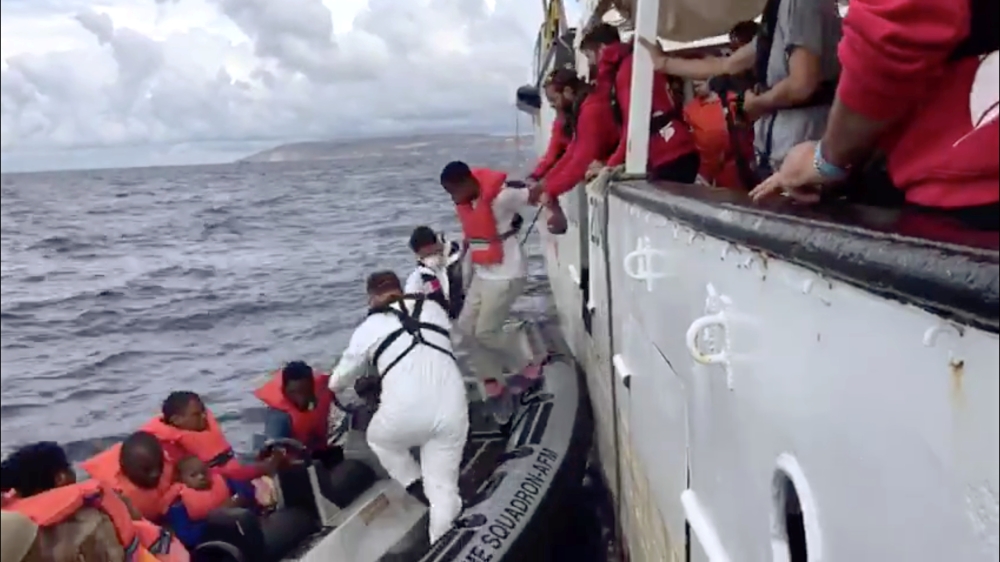 Rescued migrants leave the Open Arms boat to reach coast guards on a dinghy off the coast of Malta on Tuesday in this still image taken from a social media video. — Reuters