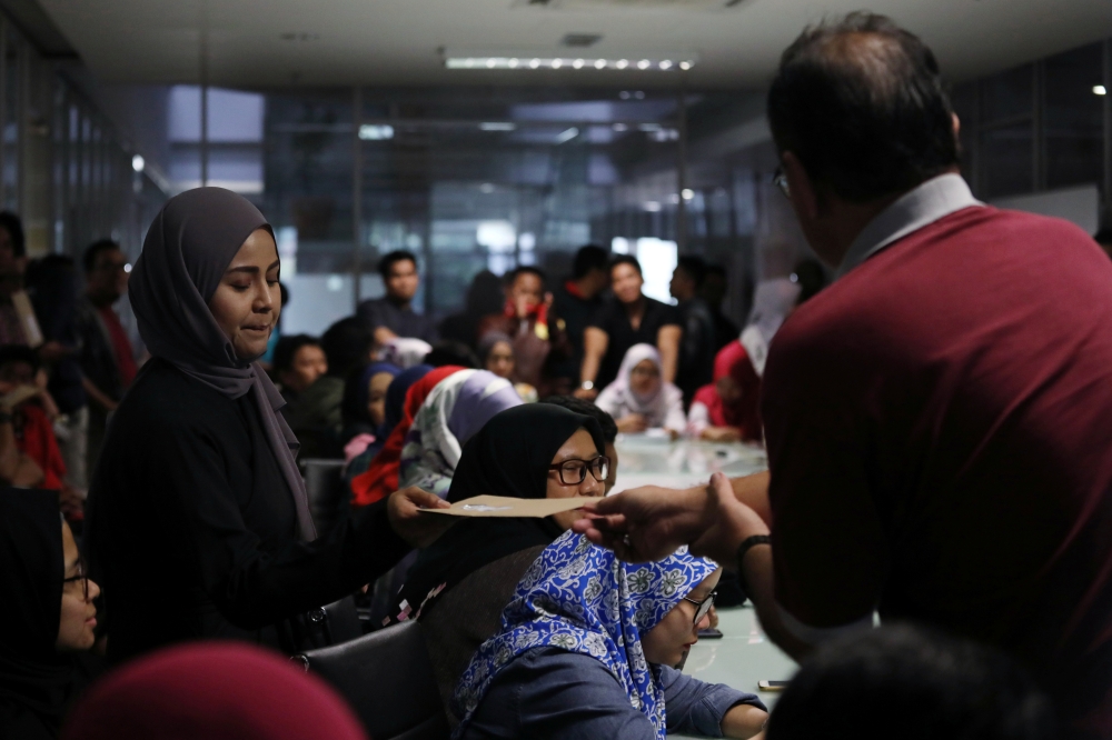 Employee receives termination letter from Utusan Malaysia management at the company's headquarters in Kuala Lumpur, Malaysia, on Wednesday. — Reuters