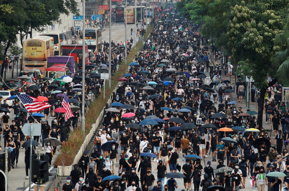 Anti-government demonstrators march in protest against the invocation of the emergency laws in Hong Kong on Saturday. -Reuters