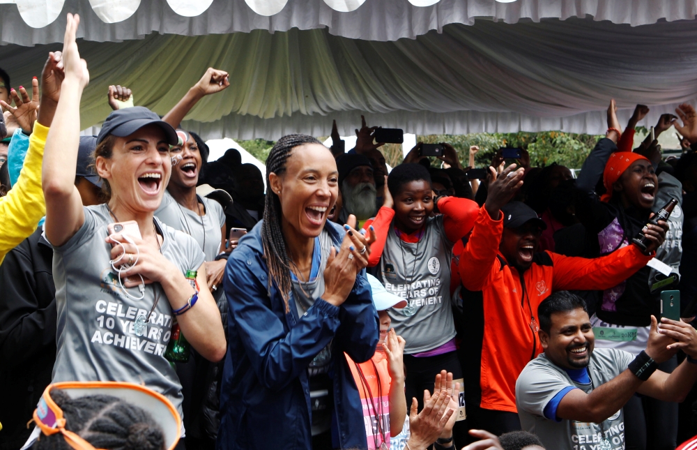 People celebrate as they watch a screen as Eliud Kipchoge, the marathon world record holder, run a marathon in under two hours in Vienna, Austria, at the Karura forest in Nairobi, Kenya, on Saturday. — Reuters
