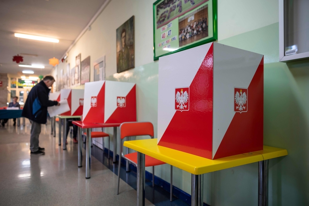 A man is seen at a polling station in Warsaw during the parliamentary elections on Sunday. -AFP