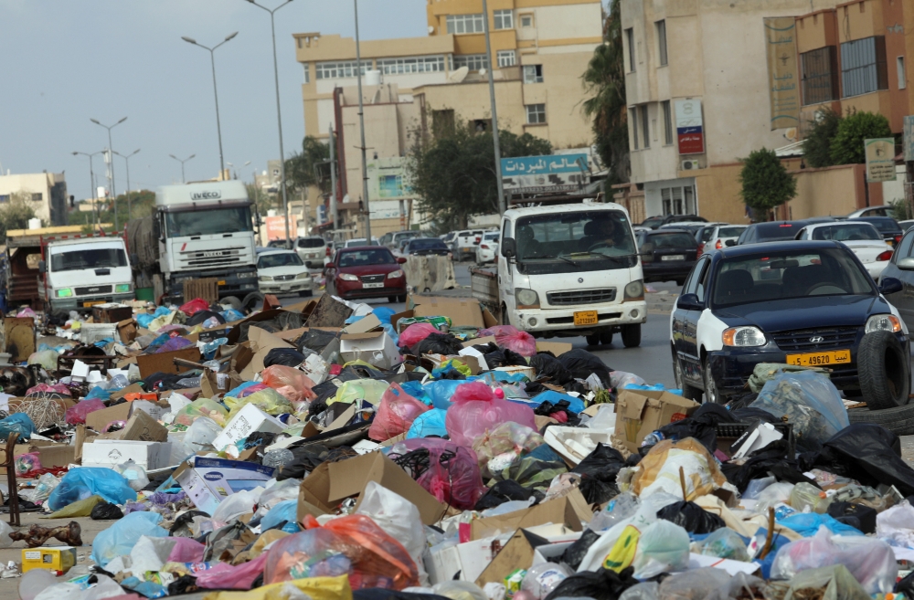 Cars pass next to mounds of rubbish piled on a street in Tripoli, Libya, in this Oct. 12, 2019 file photo. — Reuters