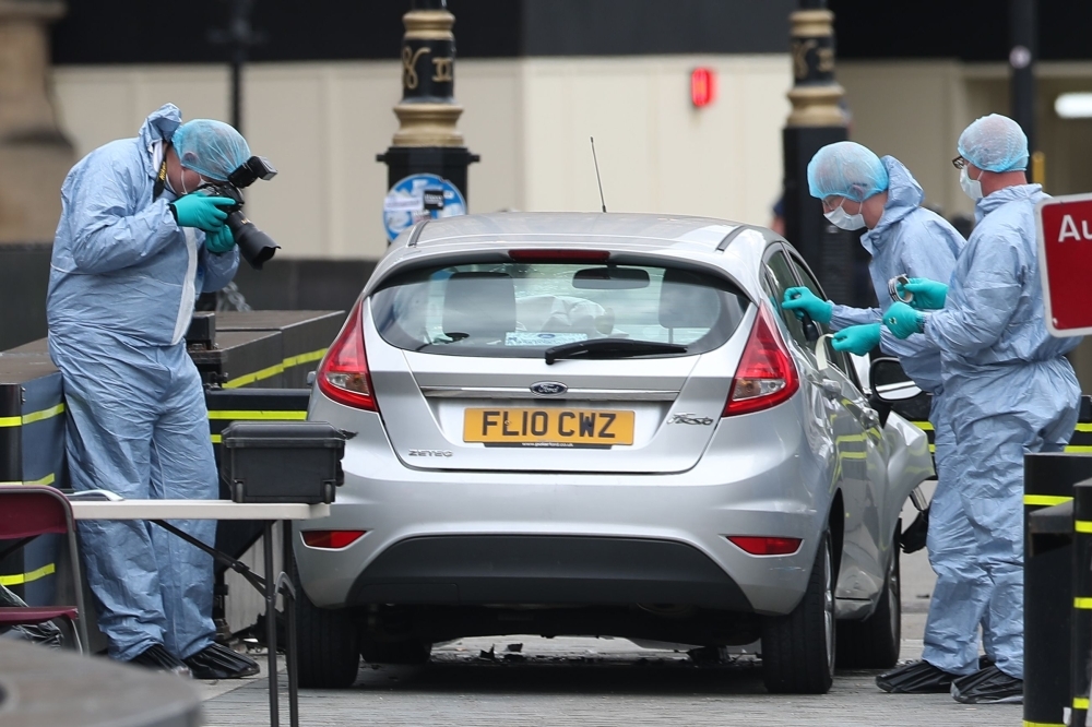 Police forensics officers work around a silver Ford Fiesta car that was driven into a barrier at the Houses of Parliament in central London in this Aug. 14, 2018 file photo. — AFP