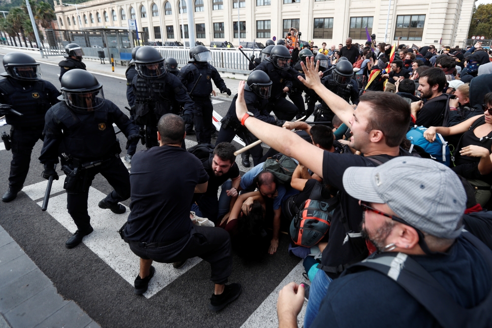 Police officers clash with Catalan demonstrators during Catalonia's general strike in Barcelona, Spain, on Friday. — Reuters