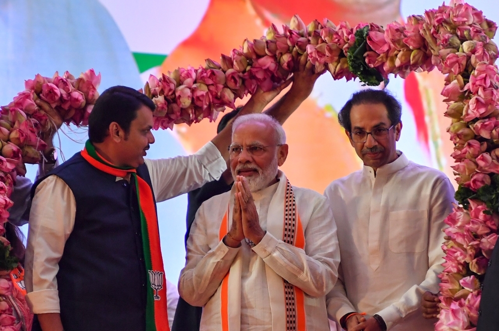 India's Prime Minister Narendra Modi, center, is being garlanded by Hindu right-wing party Shiv Sena Chief Uddhav Thackeray, right, and Chief Minister of the state Devendra Fadnavis, left, as they attend a public rally in the run up to the Maharashtra state assembly elections, in Mumbai on Friday. — AFP