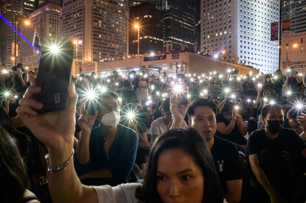 Attendees hold their mobile phones during a rally to show support for pro-democracy protesters in Hong Kong on Saturday. Hong Kong has been battered by more than four months of sometimes violent unrest that have battered the economy, sparked by a now-shelved bill allowing extraditions to the mainland but have since morphed into a movement demanding greater democracy and police accountability. — AFP