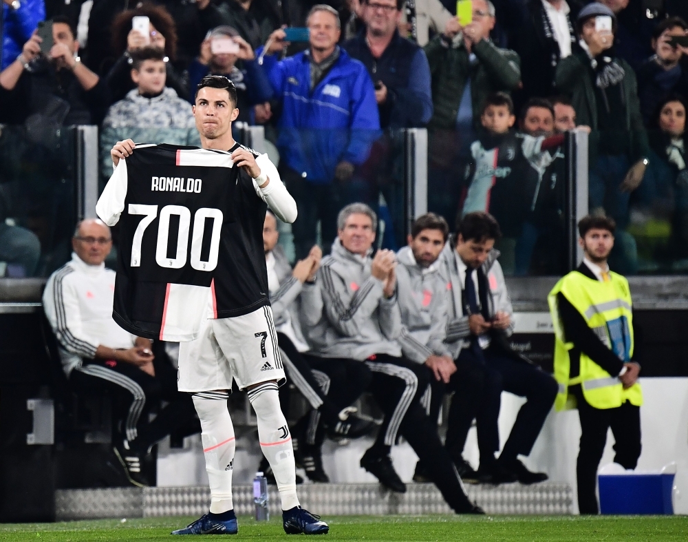 Juventus' Portuguese forward Cristiano Ronaldo holds a jersey bearing his name with the numver 700, after being honoured for having scored 700 goals so far during his career, prior to the Italian Serie A football match Juventus vs Bologna at the Juventus stadium in Turin, on Saturday. — AFP