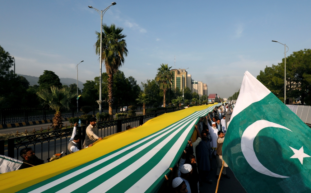 People carry Pakistan's and Azad Kashmir's flag during what they call a freedom march, to express solidarity with the people of Kashmir, in Islamabad, Sunday. —  Reuters