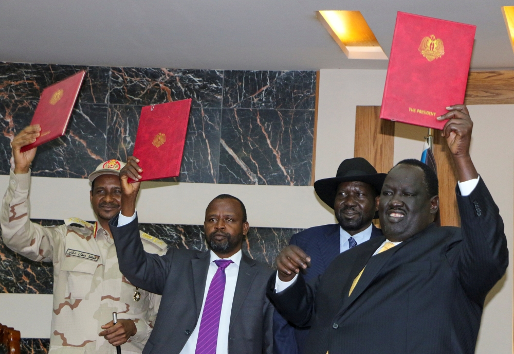 General Mohamed Hamdan Dagalo, Deputy Head of the Sudan Transitional Military Council (L), Alhadi Idris, Chairman of the Sudanese Revolutionary Front (C), South Sudan President Salva Kiir and Tut Galwak, Chairman of the South Sudanese Mediation Committee hold the agreement on peace and cease-fire during the signing ceremony in Juba, South Sudan, on Monday. — Reuters